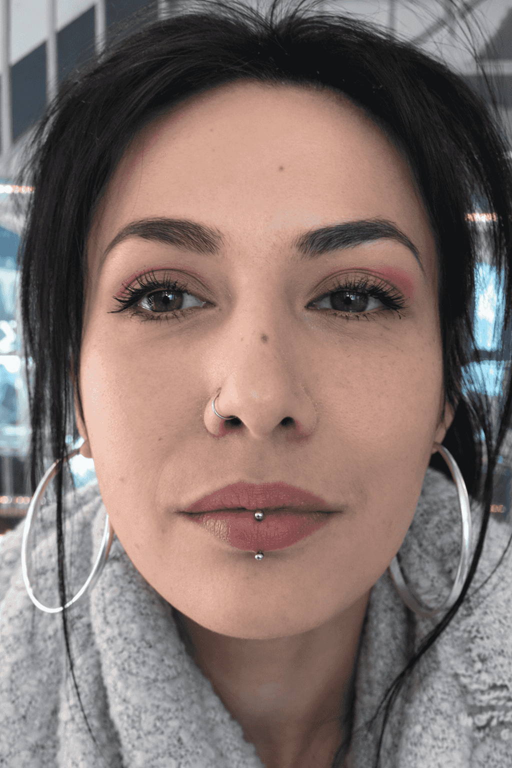femme avec piercing labret vertical et anneaux dans la narine droite