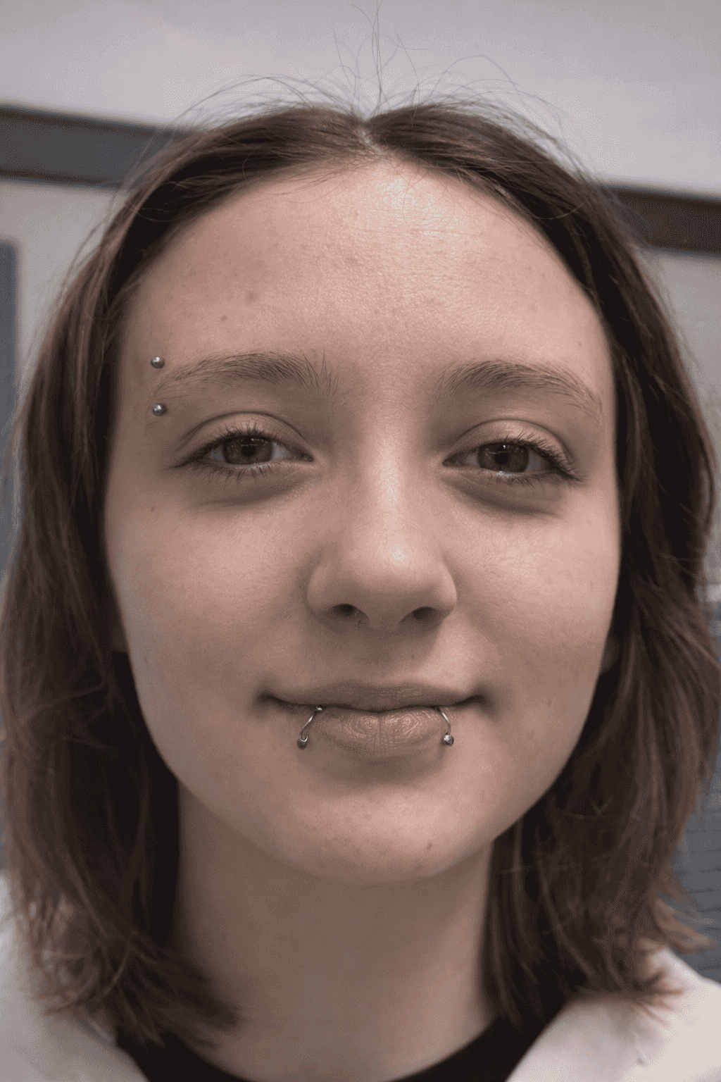 jeune femme souriante avec piercing au sourcil et snake bites