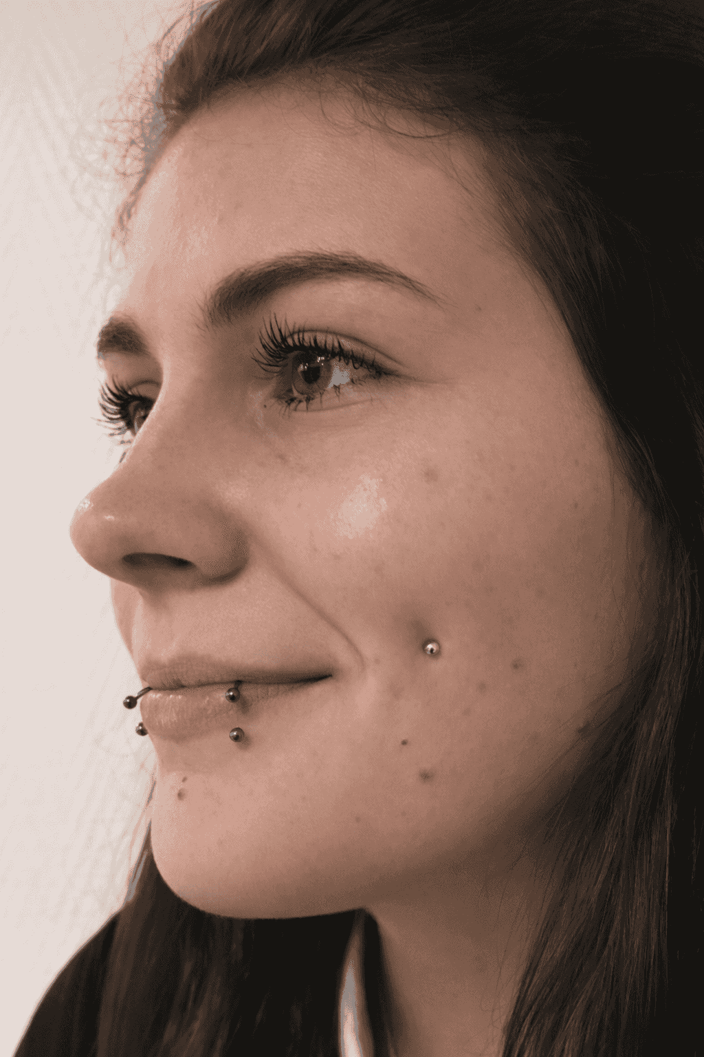 femme souriante avec dolphin bites et microdermal joue