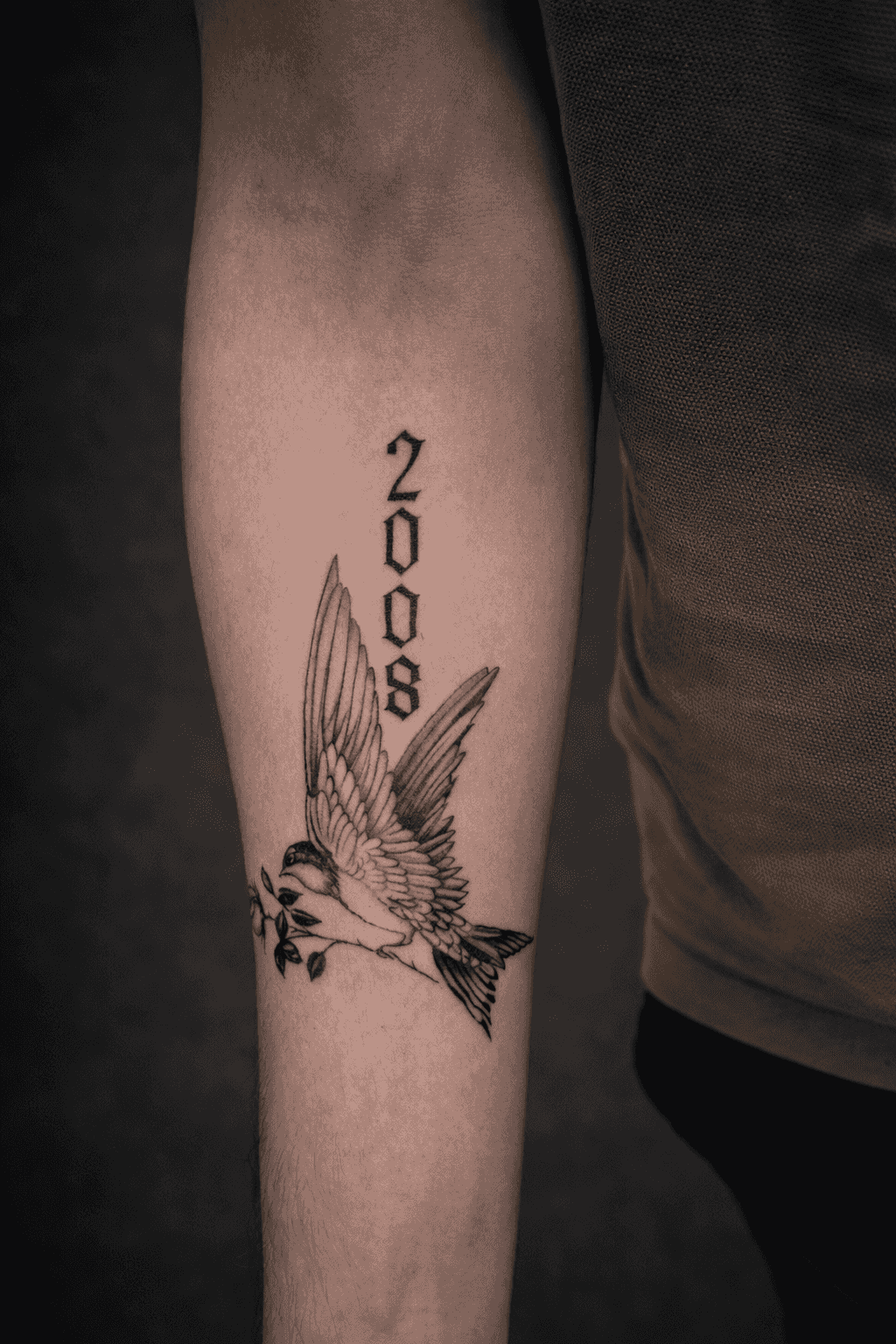 tatouage noir et gris d'une hirondelle