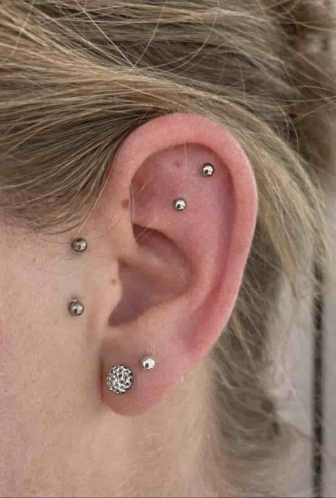 oreille de femme avec piercing tragus et double flat argenté et doré